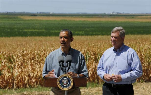 President Barack Obama talks next to Secretary of Agriculture Tom Vilsack after they tour the McIntosh family farm with the owners to view drought ridden fields of corn in Missouri Valley, Iowa, August 13, 2012.