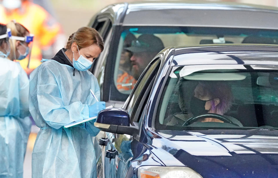 A medical worker prepares to take a sample from a person at a drive-through COVID-19 pop-up testing clinic at the Keilor Community Hub in Melbourne.