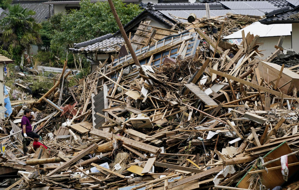 A man looks at his house and the neighborhood hit by overflowed river after heavy rains in Kuma village, Kumamoto prefecture, southern Japan Wednesday, July 8, 2020. Floodwaters flowed down streets in southern Japanese towns hit by heavy rains. (Koji Harada/Kyodo News via AP)