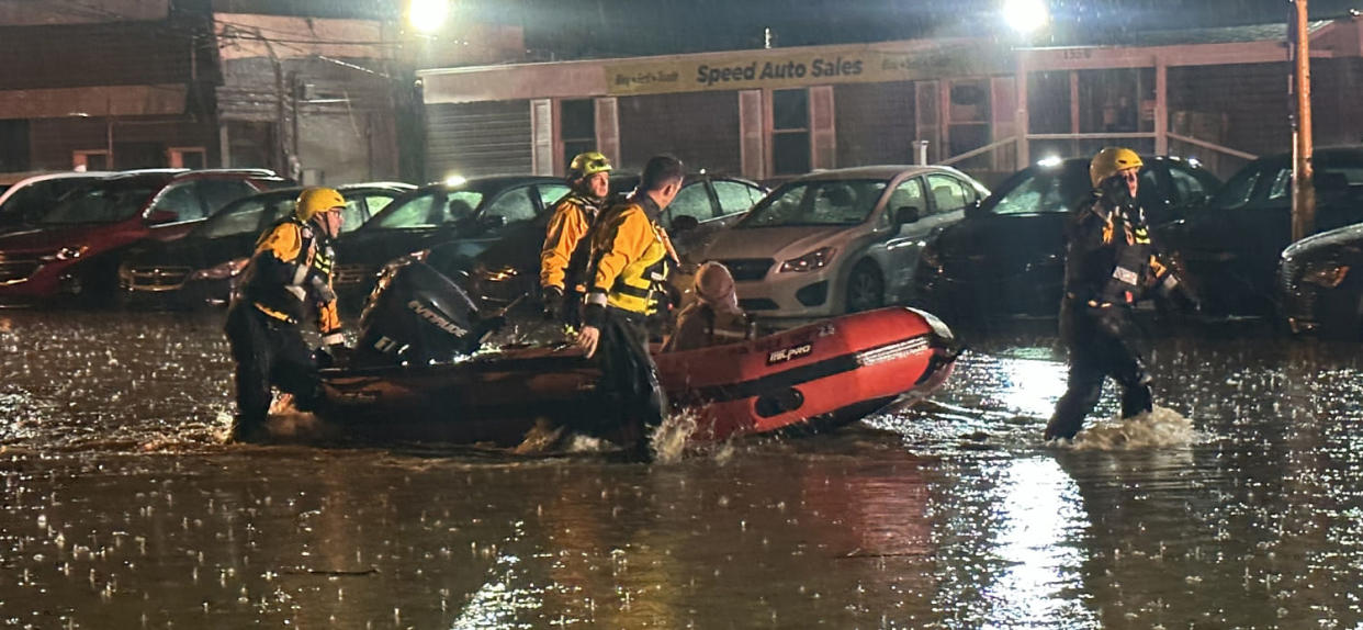 Swift-water rescue paramedics rescue a driver trapped in a vehicle in Pittsburgh on Friday. (Pittsburgh Public Safety Dept. )