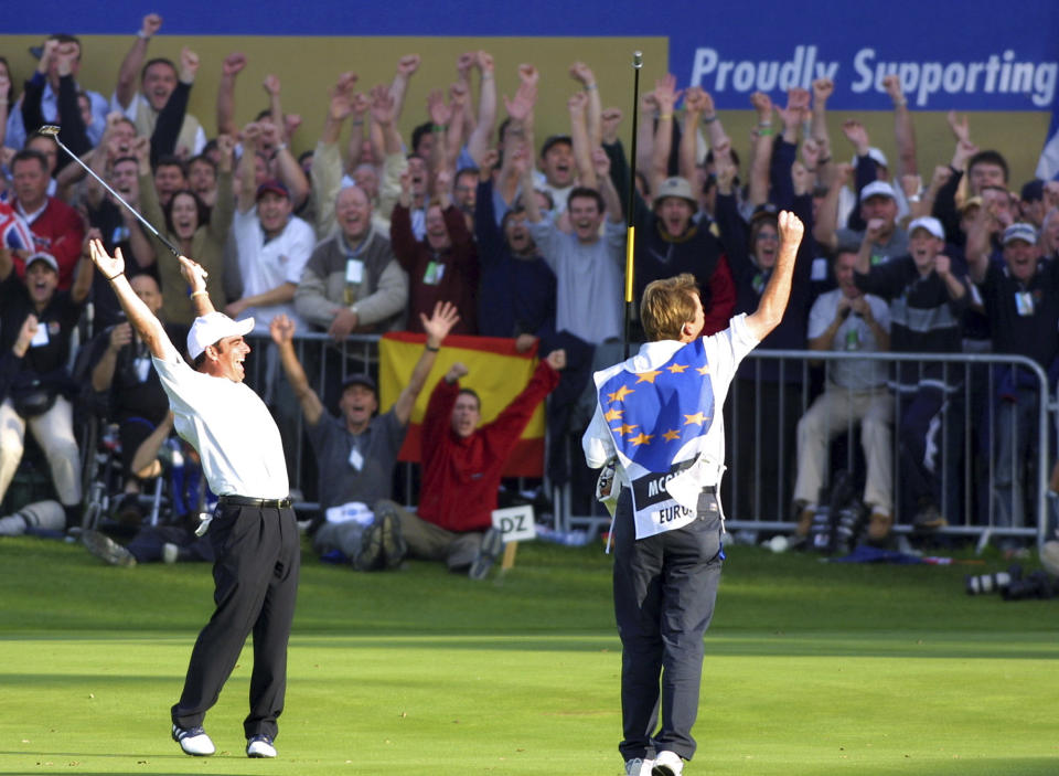 FILE - Europe's Paul McGinley, left, and his caddie JP Fitzgerald celebrate after McGinley sunk the putt that won the Ryder Cup on the final day of the Ryder Cup at The Belfry, Sutton Coldfield, England, Sunday Sept. 29, 2002. The Americans try to win the Ryder Cup in Europe for the first time since 1993 when the matches are played outside Rome on Sept. 29-Oct. 1. (AP Photo/Alastair Grant, File)