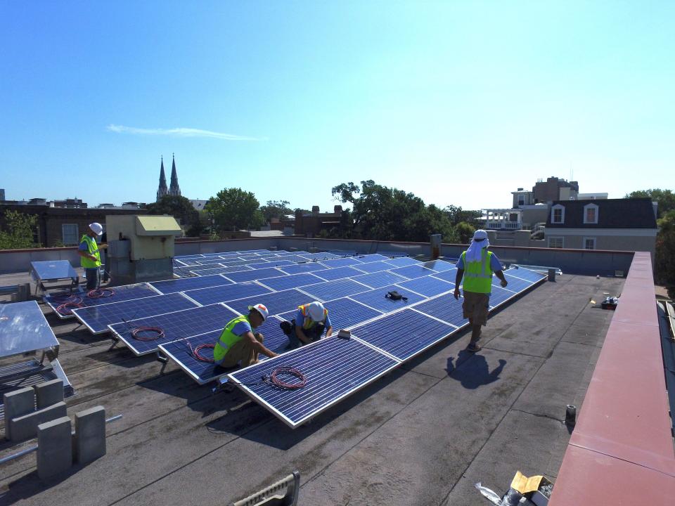 Workers with Hannah Solar install solar panels atop the United Way building in Savannah in 2016.