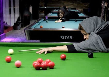 Iranian women's snooker champion Akram Mohammadi Amini (R) plays a shot during a practice session in Karaj, northwest of Tehran, Iran, in this December 8, 2015 file photo. REUTERS/Raheb Homavandi/TIMA/Files