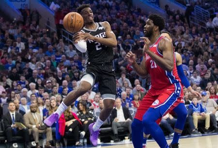 Mar 15, 2019; Philadelphia, PA, USA; Sacramento Kings guard Buddy Hield (24) passes the ball against Philadelphia 76ers center Joel Embiid (21) during the third quarter at Wells Fargo Center. Mandatory Credit: Bill Streicher-USA TODAY Sports