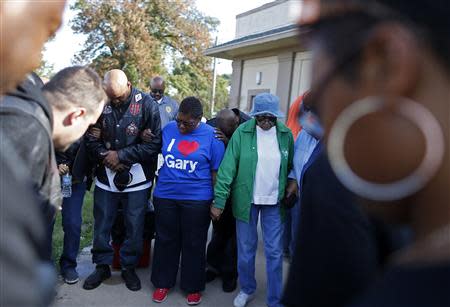 Mayor Karen Freeman-Wilson (C) takes part in a group prayer before the start of a neighborhood clean-up project in Gary, Indiana, September 28, 2013. REUTERS/Jim Young