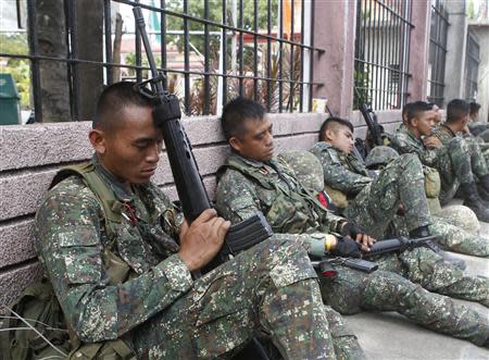 Members of the Philippine Marines rest on a road pavement on the fourth day of a government stand-off with the Moro National Liberation Front (MNLF) rebels in downtown Zamboanga city in southern Philippines September 12, 2013. REUTERS/Erik De Castro