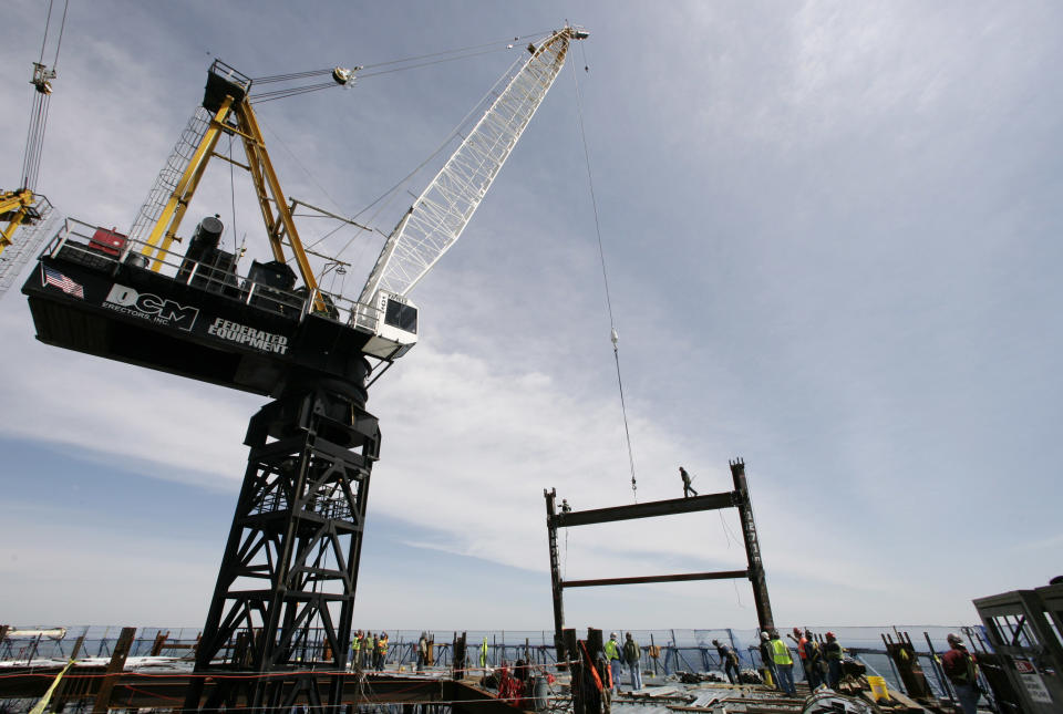 A crane on the top deck of One world Trade Center holds a steel beam between two columns to make the tower New York City's tallest skyscraper, Monday, April 30, 2012 in New York. One World Trade Center is being built to replace the twin towers destroyed in the Sept. 11 attacks. It reached just over 1,250 feet on Monday. That's just taller than the observation deck on the Empire State Building. (AP Photo/Mark Lennihan, Pool)