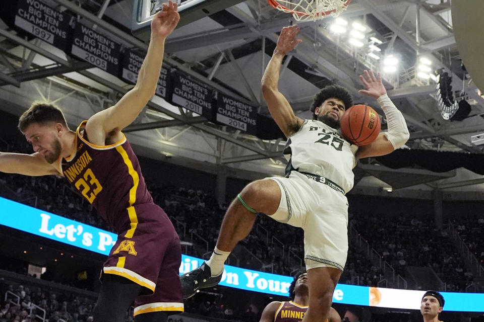 Michigan State forward Malik Hall (25) dunks as Minnesota forward Parker Fox (23) defends during the second half of an NCAA college basketball game, Thursday, Jan. 18, 2024, in East Lansing, Mich. (AP Photo/Carlos Osorio)