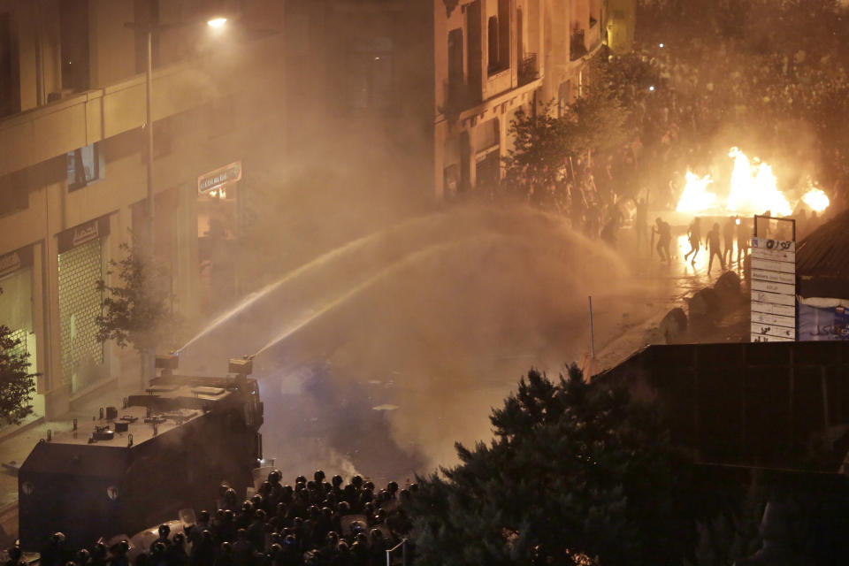 Lebanese riot police use water cannon on anti-government protesters during a protest against government's plans to impose new taxes in Beirut, Lebanon, Friday, Oct. 18, 2019. Demonstrators in Lebanon are blocking major roads across the country in a second day of protests against proposed new taxes, which come amid a severe economic crisis. (AP Photo/Hassan Ammar)