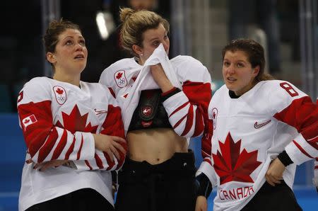 Ice Hockey - Pyeongchang 2018 Winter Olympics - Women Final Match - Gangneung Hockey Centre, Gangneung, South Korea, February 22, 2018 - Laura Stacey (C) of Canada wipes her eyes as she stands with teammates Lauriane Rougeau (L) and Laura Fortino after losing the gold medal game to Team USA. REUTERS/Grigory Dukor