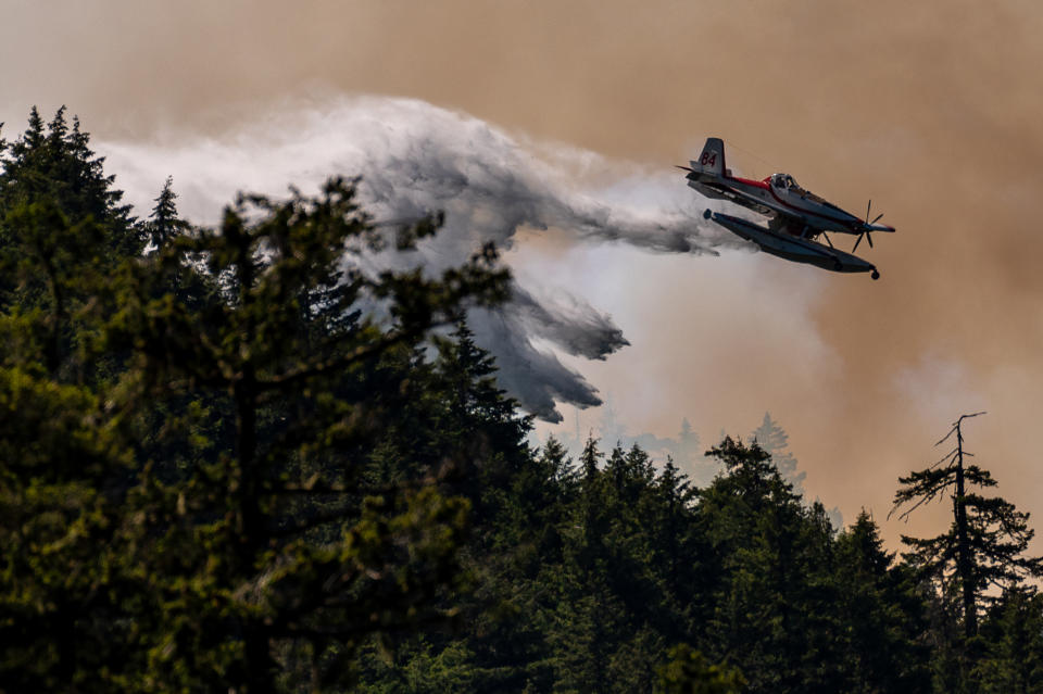 A fixed wing waterbomber drops water onto the Cameron Bluffs wildfire near Port Alberni, British Columbia, Canada, on Tuesday, June 6, 2023. Canada is on track to see its worst-ever wildfire season in recorded history if the rate of land burned continues at the same pace. Photographer: James MacDonald/Bloomberg