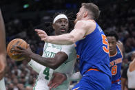 Boston Celtics guard Jrue Holiday (4) drives toward the basket as New York Knicks center Isaiah Hartenstein (55) defends during the first half of an NBA basketball game Thursday, April 11, 2024, in Boston. (AP Photo/Steven Senne)