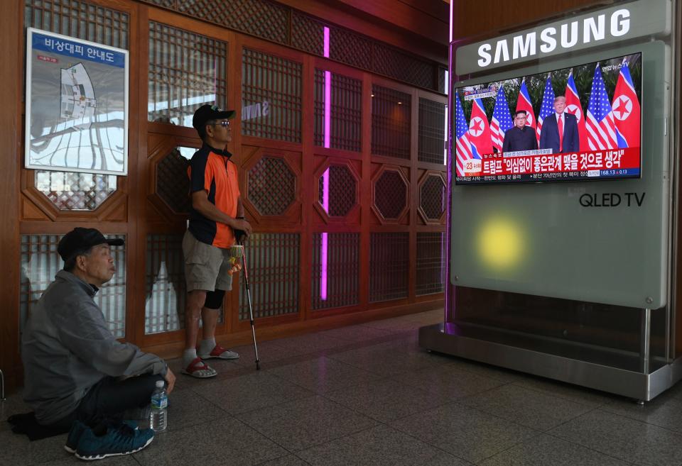 <p>People watch a television news screen showing the summit between President Donald Trump and North Korean leader Kim Jong Un in Singapore, at a railway station in Seoul on June 12, 2018. (Photo: Jung Yeon-je/AFP/Getty Images) </p>