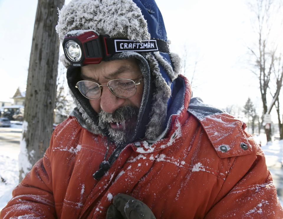 In this Monday, Dec. 12, 2016 photo, ice forms in Carl Bentson's beard and mustache as he clears sidewalks near Colborne Street and St. Clair Avenue in St. Paul, Minn. Temperatures dipped below zero for the first time this winter and will hover near there for most of the week. (Scott Takushi /Pioneer Press via AP)