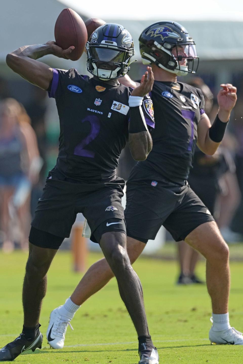 Ravens quarterbacks Tyler Huntley and Trace McSorley throw passes during practice.