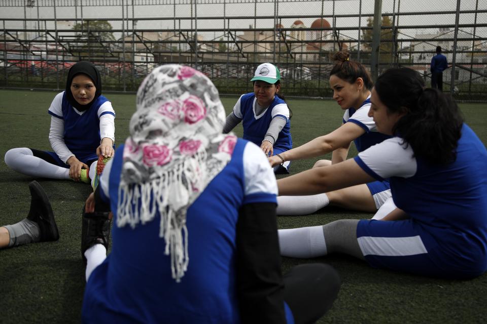 In this Wednesday, April 24, 2019 photo, members of Hestia FC Women's Refugee Soccer team warm up during a training session in Athens. Many of the players at Hestia FC weren't allowed to play or even watch soccer matches in their home countries. Hestia FC was set up by the Olympic Truce Centre, a non-government organization created in 2000 by the International Olympic Committee and Greek Foreign Ministry. (AP Photo/Thanassis Stavrakis)