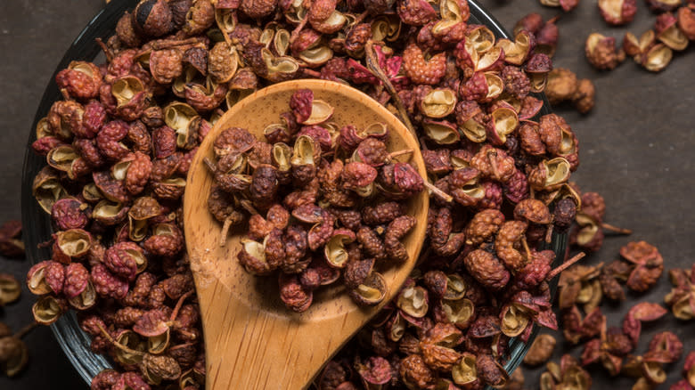 Pile of sichuan peppercorns on wooden spoon