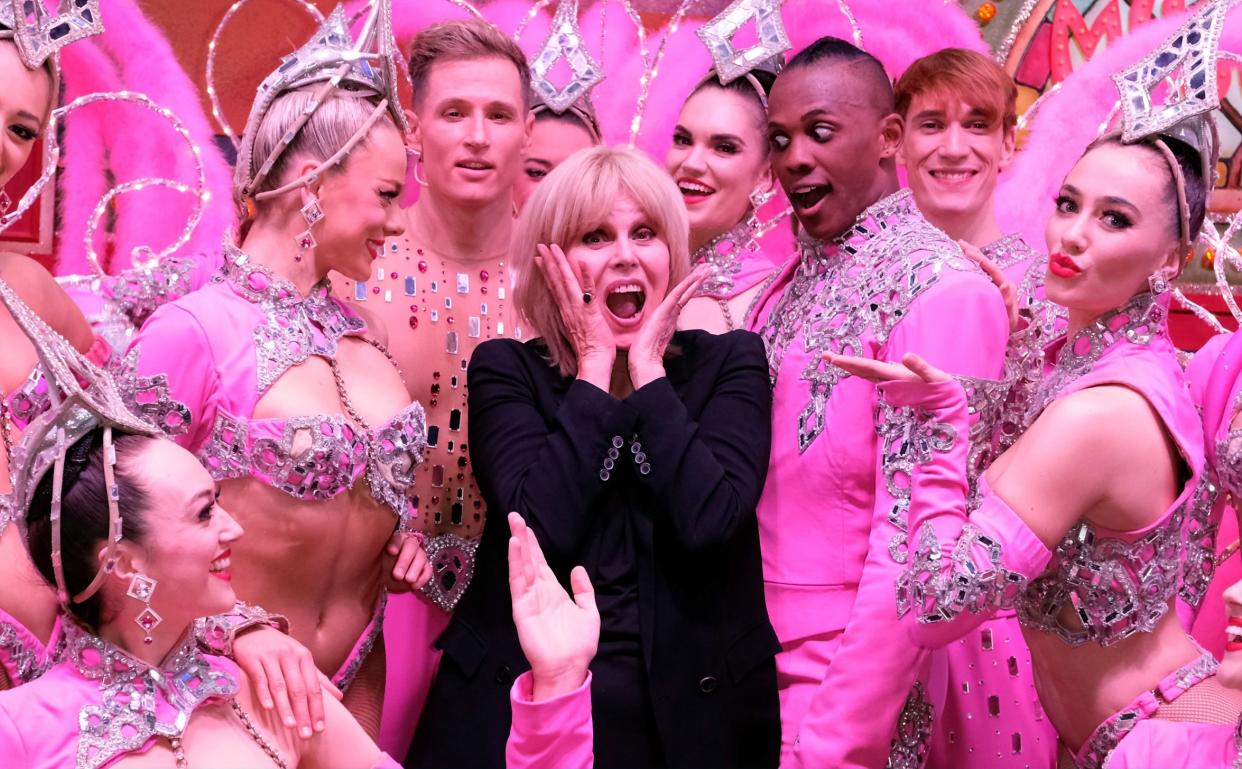 Joanna Lumley poses with performers at the Moulin Rouge - Getty