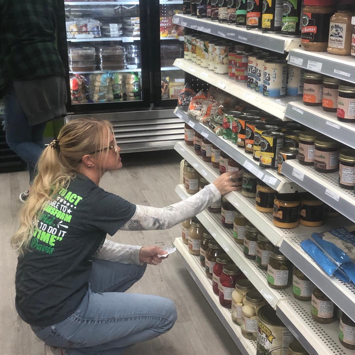 Store clerk Melissa Applegate adds a label to shelves with canned and jarred products inside the new StarkFresh location at 405 S. Linden Ave. in Alliance. The Canton-based nonprofit celebrated the grand opening of its Alliance store on Monday, Oct. 9, 2023.