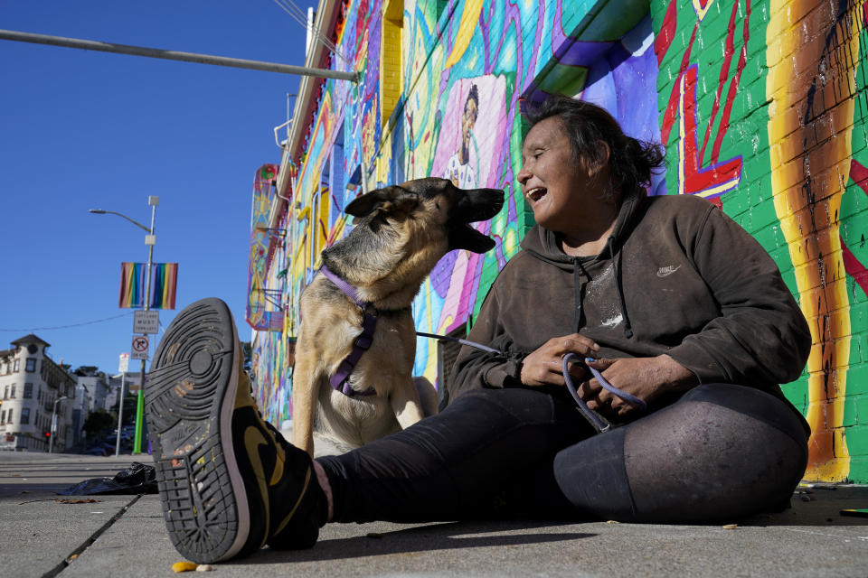 Victoria Solomon plays with her dog, Gypsy, as she waits for her belongings to dry in San Francisco, Monday, Dec. 12, 2022. (AP Photo/Godofredo A. Vásquez)