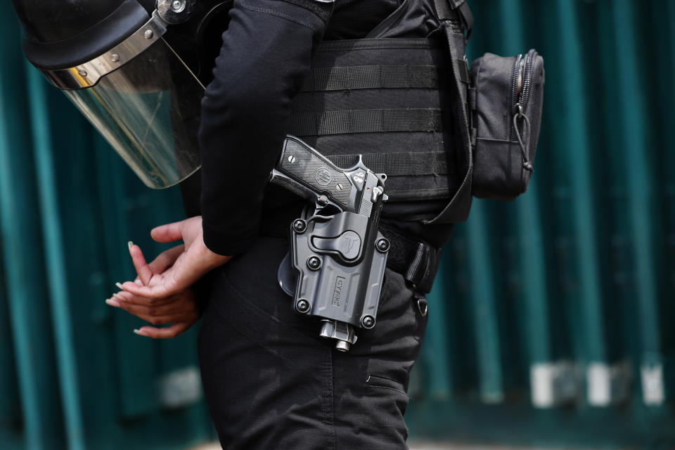 A police officer stands outside the closed headquarters of the Institutional Revolutionary Party of Mexico, PRI, in Mexico City, on Wednesday, June 30, 2021. The doors were closed after party dissidents set up a ring of protesters Tuesday around the headquarters and fighting apparently broke out when a squad of loyalists tried to retake the building. (AP Photo/Marco Ugarte)