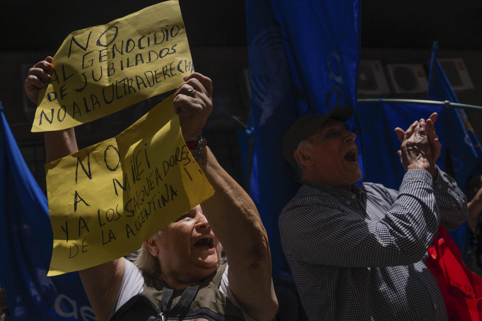 A protester holds up a sign that reads in Spanish "No to the genocide of the retired, no to the ultra-right," and "No to Milei and the looters of Argentina" during a demonstration in support of a national strike in Argentina against the economic and labor reforms proposed by Argentine President Javier Milei, outside Argentina's embassy in Montevideo, Uruguay, Wednesday, Jan. 24, 2024. (AP Photo/Matilde Campodonico)
