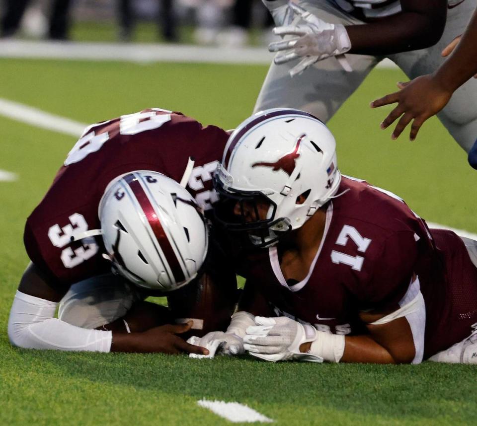 North Side tight end Dallas Austin (33) and defensive lineman Bryan Duran (17) recover an O.D. Wyatt fumble in the first half of a UIL football game at Farrington Field in Fort Worth, Texas, Friday, Oct. 06, 2023. Wyatt led North Side 13-7 at the half. (Special to the Star-Telegram Bob Booth)