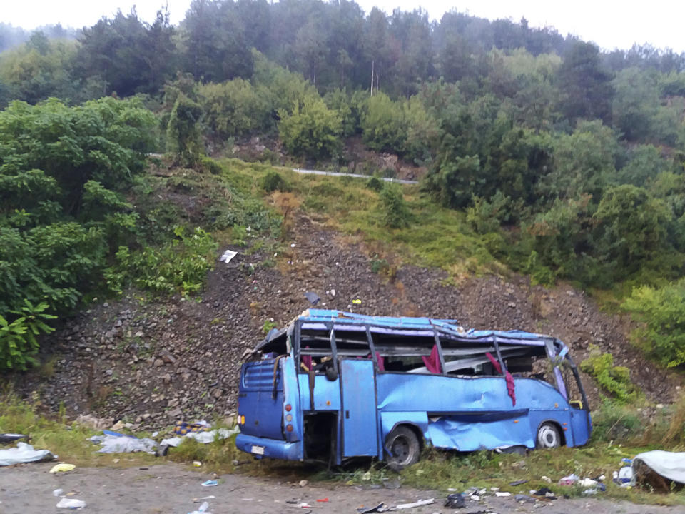 In this handout photo provided by the Bulgarian Interior Ministry, a view of a bus that crashed and overturned, near the town of Svoge, Saturday, Aug. 25, 2018. Bulgaria's health minister says a tourist bus has flipped over on a highway near Sofia, the capital, killing at least 15 people and leaving 27 others injured. Police said a bus carrying tourists on a weekend trip to a nearby resort overturned and then fell down a side road 20 meters (66 feet) below the highway. (Bulgarian Interior Ministry via AP)