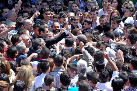 President Bashar al-Assad greets his supporters at a school in an undisclosed location during an event to commemorate Syria's Martyrs' Day May 6, 2015 in this handout provided by SANA. REUTERS/SANA/Handout via Reuters