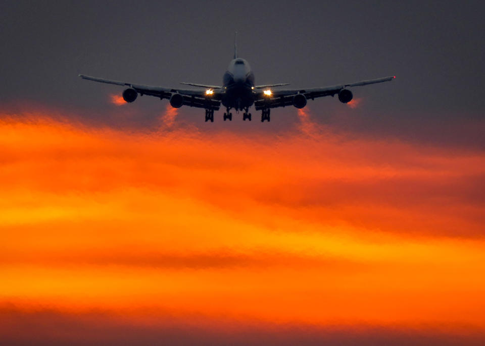 An aircraft approaches the international airport in Frankfurt, Germany, as the sun rises on Monday, Aug. 9, 2021. (AP Photo/Michael Probst)
