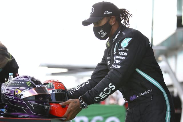Lewis Hamilton places Michael Schumacher's helmet next to his own
