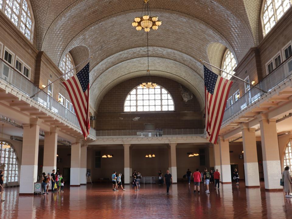 Ellis Island's main room with a few people milling about