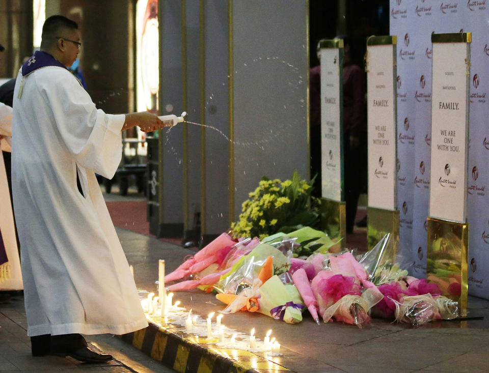 <p>A Catholic priest sprinkles holy water on a memorial during a mass for victims of an attack at the Resorts World Manila complex, Friday, June 2, 2017, in Manila, Philippines. (Photo: Aaron Favila/AP) </p>