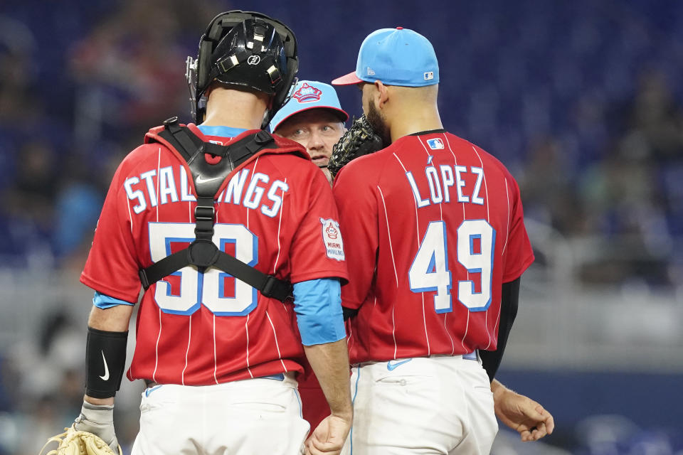 Miami Marlins pitching coach Andrew Bailey talks to pitcher Pablo Lopez (49) and catcher Jacob Stallings (58) as the bases are loaded during the fourth inning of a baseball game against the San Francisco Giants, Saturday, June 4, 2022, in Miami. (AP Photo/Marta Lavandier)