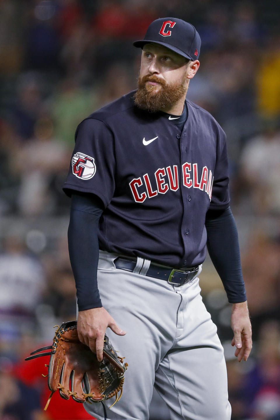 Cleveland Guardians relief pitcher Bryan Shaw watches a replay of a grand slam by the Minnesota Twins as he leaves the field during the fifth inning of a baseball game Friday, May 13, 2022, in Minneapolis. (AP Photo/Bruce Kluckhohn)