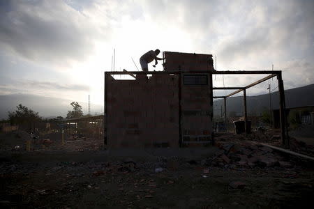 A man dismantles his house which has been marked for demolition, to carry it by parts to Colombia through the Tachira river at San Antonio in Tachira state, Venezuela, August 27, 2015. Shaken by the deportation of over a thousand compatriots, Venezuela's roughly 5 million Colombians are grappling with whether to stay on in the crisis-hit country that has become increasingly unlivable. REUTERS/Carlos Garcia Rawlins