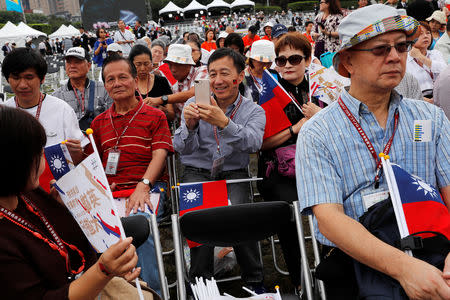 Audience members pose with Taiwanese flags before the National Day celebrations in Taipei, Taiwan October 10, 2018. REUTERS/Tyrone Siu