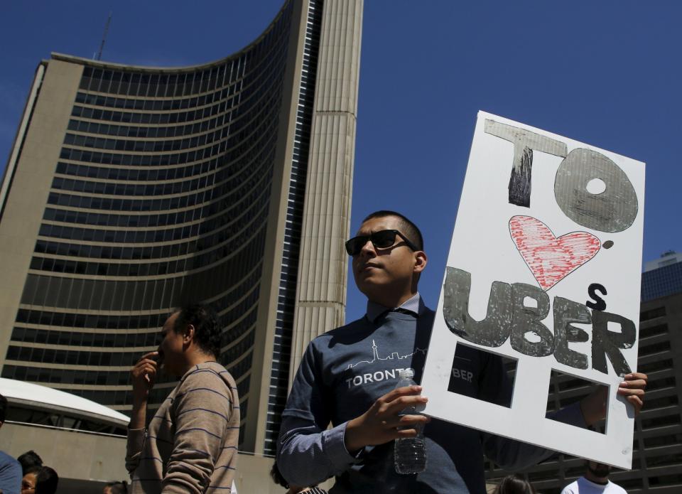 An Uber supporter holds a placard during a rally in front of city hall in Toronto May 6, 2015. (REUTERS/Chris Helgren)