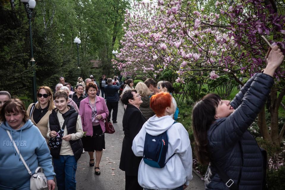 Kharkiv residents enjoy magnolia blossoming trees in the Gorkiy Park in the center of Kharkiv, Ukraine, on April 21, 2024. (Serhii Korovayny/The Kyiv Independent)