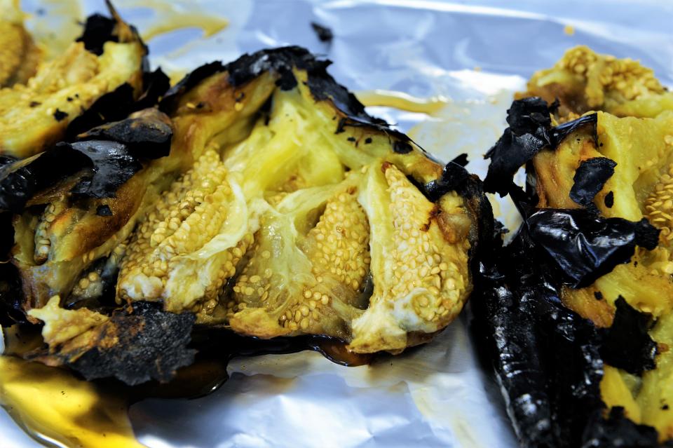 Roasted eggplants are split to cool. The pulp will be removed from the skins and used as the basis for an array of dips.