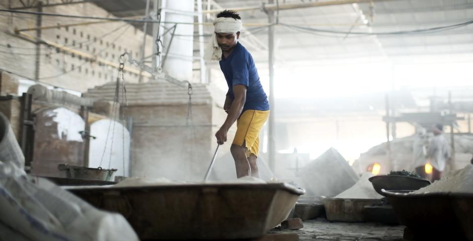 A craftsmen sifts through sand in a tray