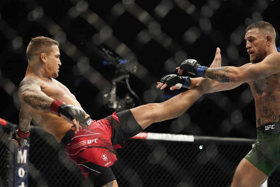 Conor McGregor, right, tries to avoid a kick from Dustin Poirier during a UFC 264 lightweight mixed martial arts bout Saturday, July 10, 2021, in Las Vegas. (AP Photo/John Locher)