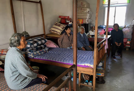 Local residents Fei Jinxian (L), Gu Wenfeng (2nd L) and neighbours watch a TV broadcast of President Xi Jinping's unveiling of the new Politburo Standing Committee in Fengxian, a rural suburb of Shanghai, China October 25, 2017. REUTERS/David Stanway