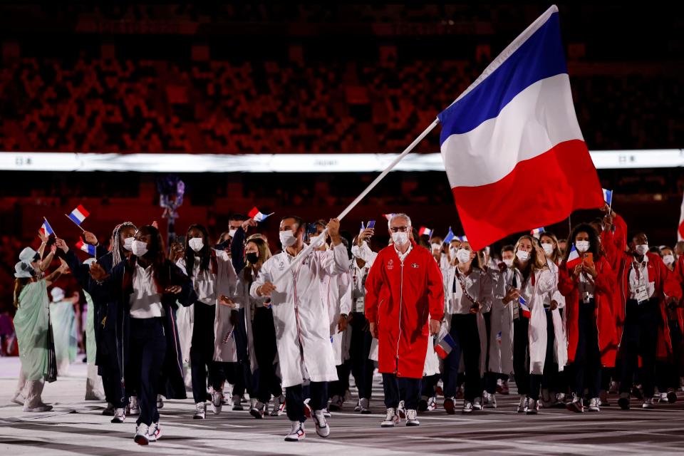 <p>France's flag bearers Clarisse Agbegnenou (L) and Samir Ait Said (C) lead their delegation as they parade during the opening ceremony of the Tokyo 2020 Olympic Games, at the Olympic Stadium, in Tokyo, on July 23, 2021. (Photo by Odd ANDERSEN / AFP) (Photo by ODD ANDERSEN/AFP via Getty Images)</p> 