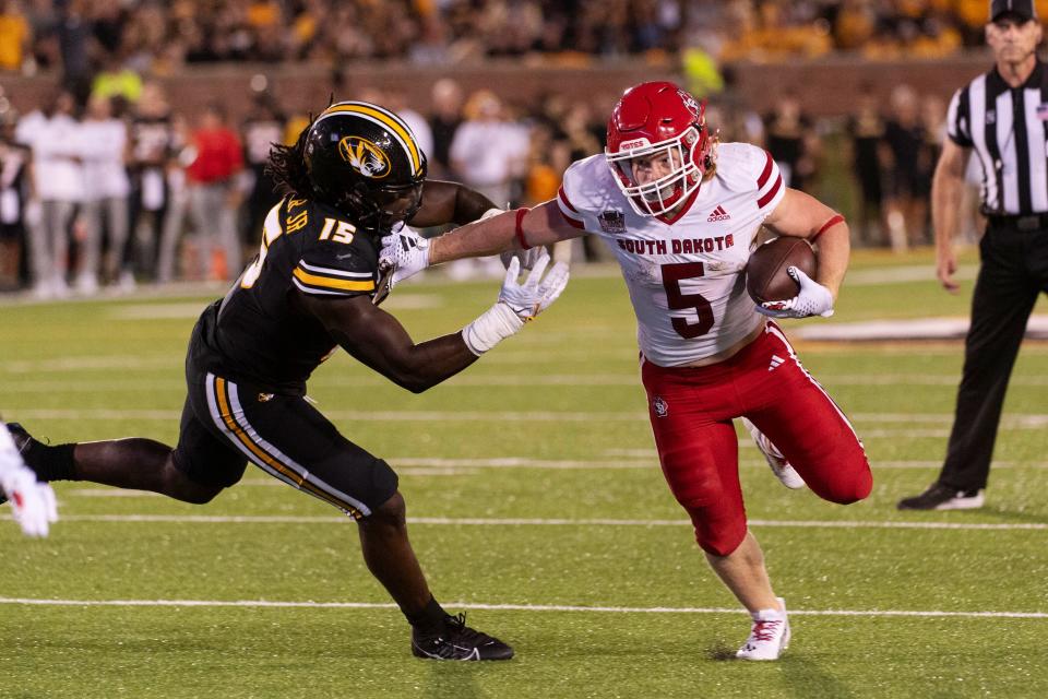 South Dakota running back Travis Theis, right, pushes past Missouri defensive lineman Johnny Walker Jr., left, during the second quarter of an NCAA college football game Thursday, Aug. 31, 2023, in Columbia, Mo.