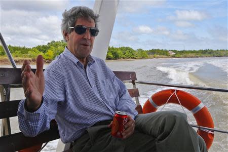 U.S. Secretary of State John Kerry talks to reporters while riding a boat on the Mekong River Delta December 15, 2013. REUTERS/Brian Snyder