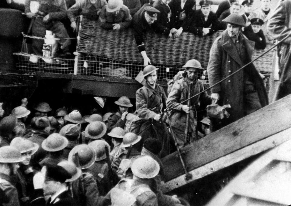 soldiers clamber on to boat wearing hard hats and uniform
