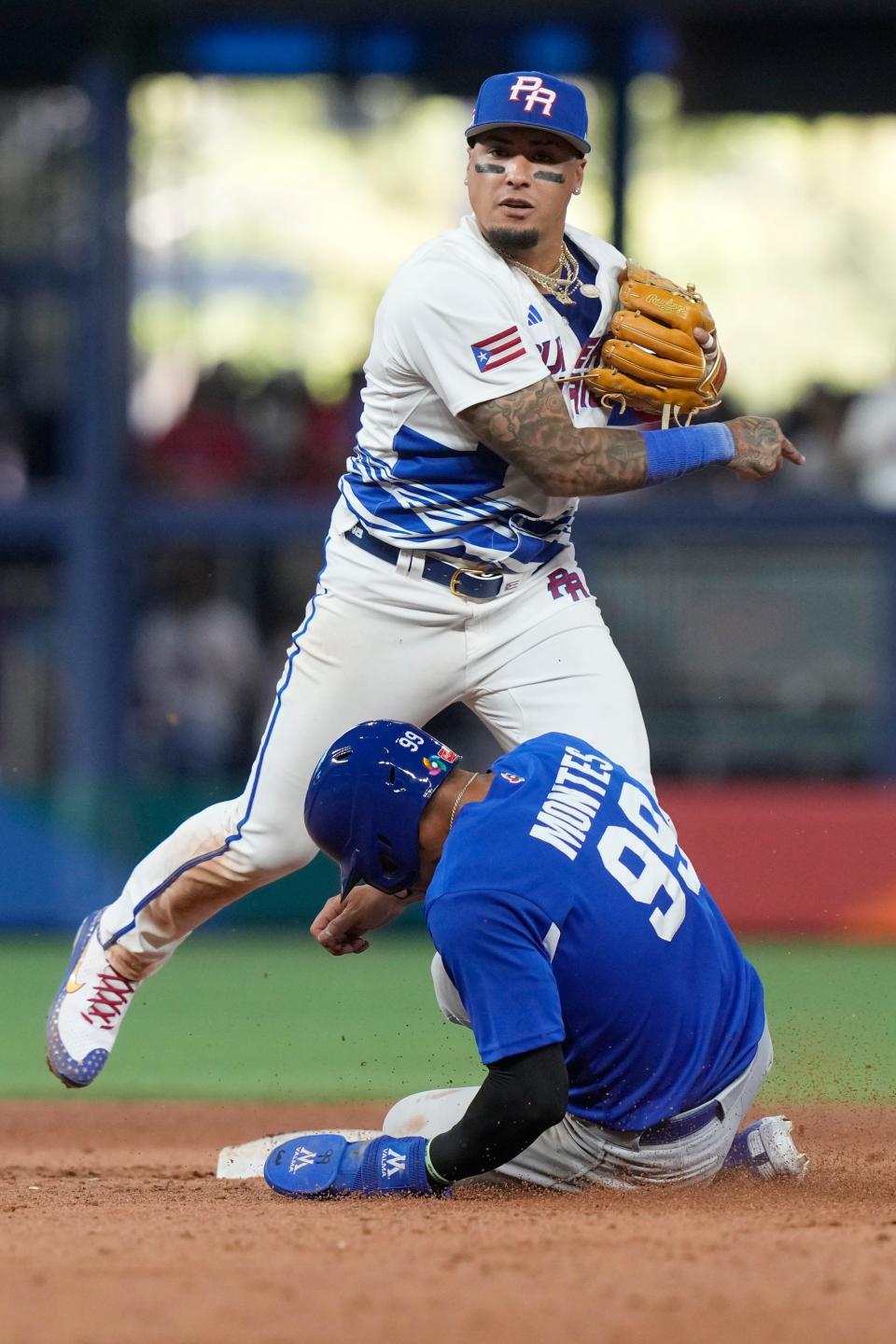 Puerto Rico second baseman Javier Baez completes the double play as Nicaragua Juan Diego Montes slides during the ninth inning of a World Baseball Classic game against Nicaragua, Saturday, March 11, 2023, in Miami.