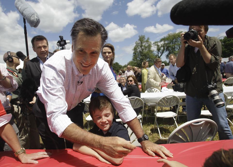 Former Massachusetts Gov. Mitt Romney leans over a little boy to greet supporters before he announced he is running for president of the United States onJune 2, 2011, during a campaign event at Bittersweet Farm in Stratham, N.H. | Stephan Savoia, Associated Press