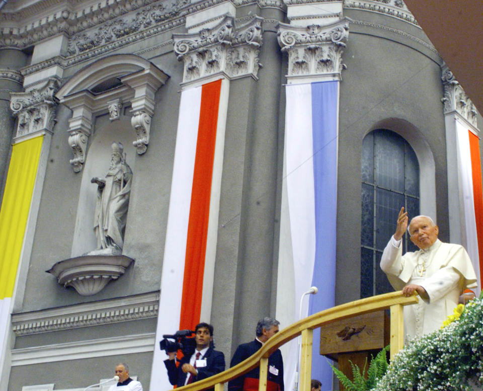 FILE - In this June 16, 1999 file photo Pope John Paul II waves from outside the basilica during his visit to Wadowice, Poland, the town where he was born and grew up. The basilica was his parish church, where he was baptized, served as an altar boy and stopped to pray on his way to school. A central point in Wadowice, the basilica has a chapel dedicated to John Paul with a reliquary containing a drop of his blood. (AP/Photo Rudi Blaha, File)